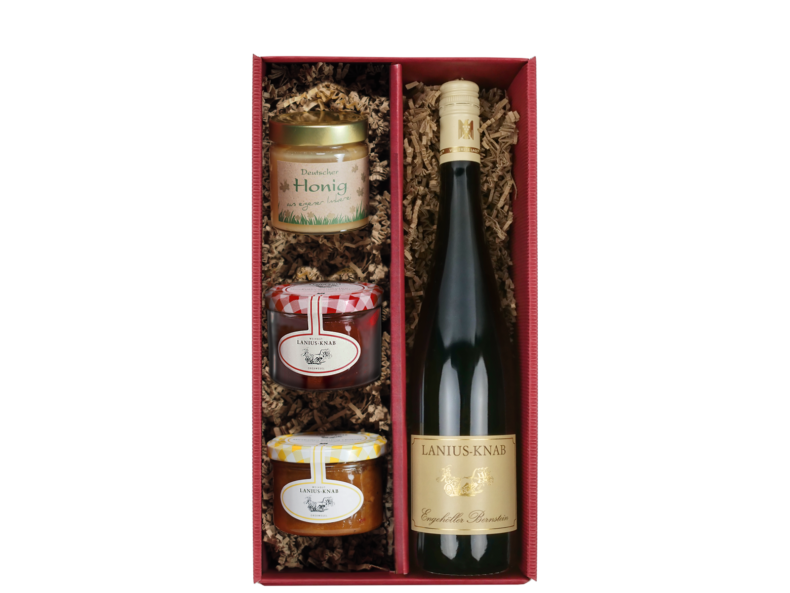 Geschenkkarton mit einer Flasche Wein, einem Glas Honig, einem Glas Mirabellen-Chutney und einem Glas Rotweingelee