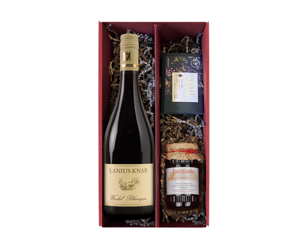 Rotes Geschenkpaket mit einer Flasche Rotwein, einer kleinen Schokoladentafel und einem Glas gefüllt mit rotem Gelee