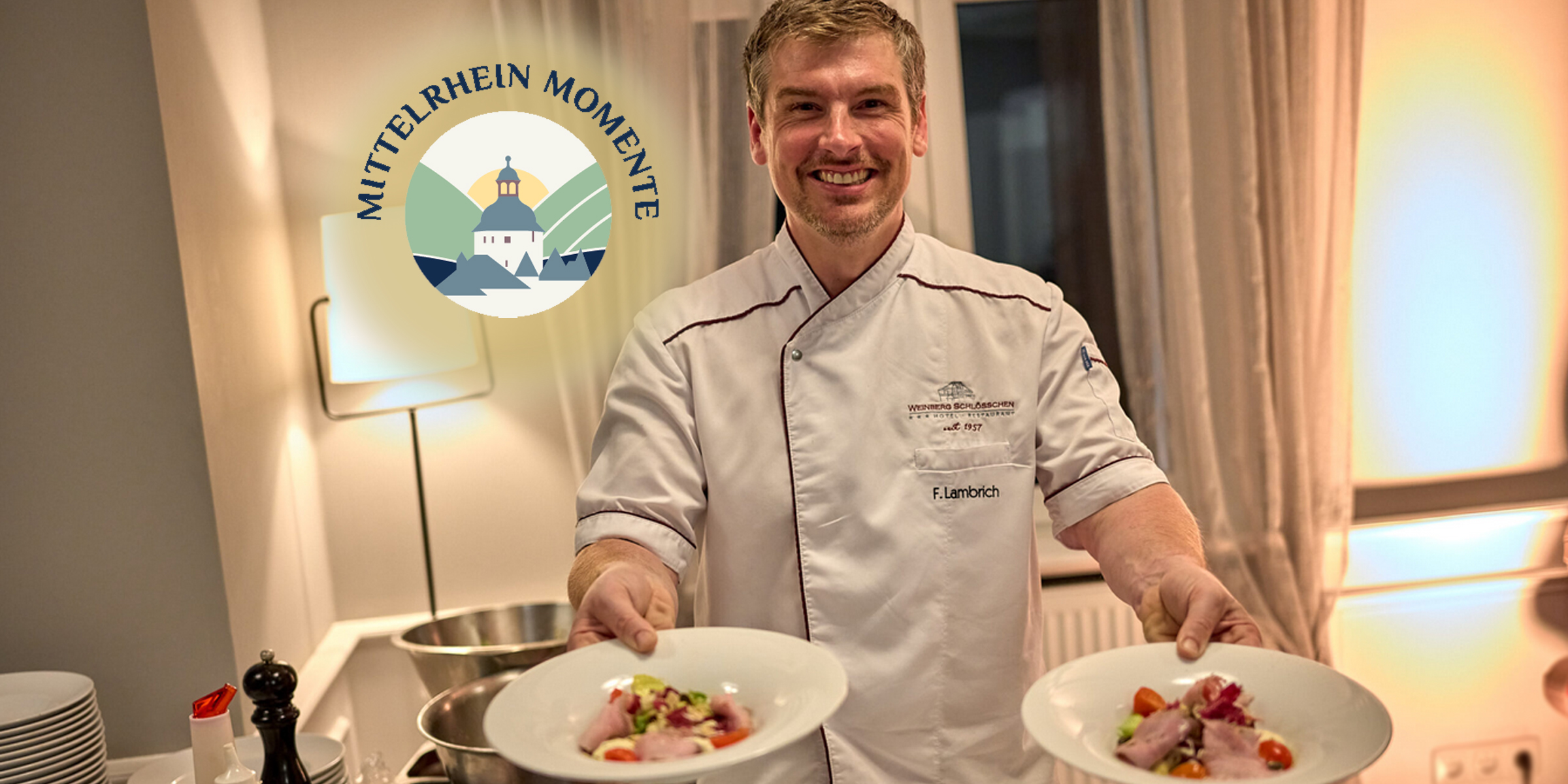 Koch in Kochjacke hält zwei gefüllte Teller.